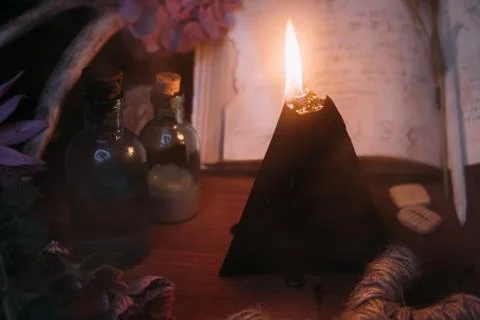 Open old book with magic spells, runes, black candle Stock Photos