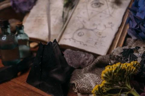 Open old book with magic spells, runes, black candle Stock Photos