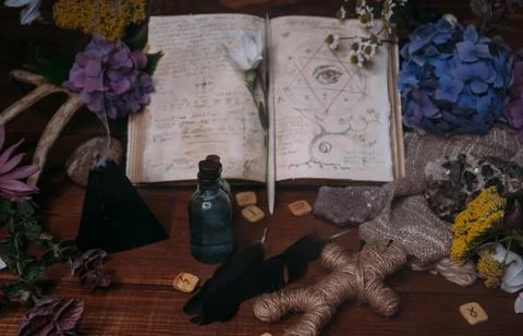 Open old book with magic spells, runes, black candle Stock Photos