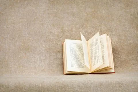 Open old book on a rough brown sacking Stock Photos