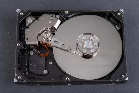 Open old computer disk on the table. Computer head and data carrier. Stock Photos