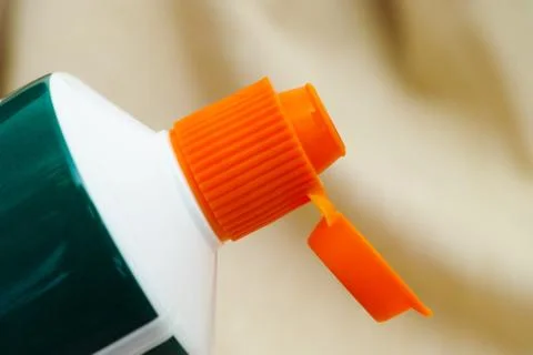 Open orange cap of toothpaste tube Stock Photos