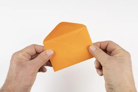 An open orange envelope in the hands Foto stock