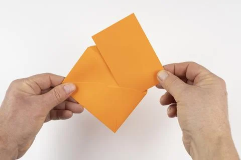An open orange envelope in the hands Foto stock