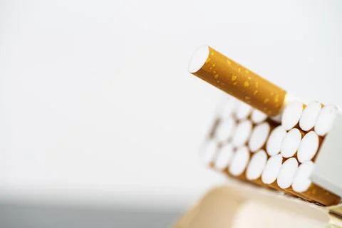 Open pack of cigarettes with one outstretched cigarette close up, place for t Stock Photos