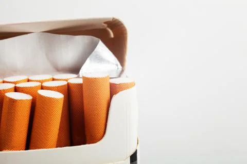 Open pack of cigarettes with a red filter close-up on a white background, pla Stock Photos