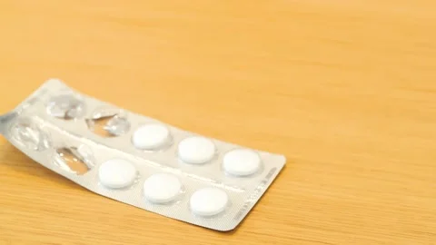 An open package of pills is on the table. White pills, quick help, home Stock Footage 270377476