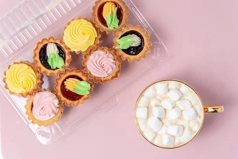 Open packaging with sweets and a cup of hot chocolate with marshmellows on the Stock Photos