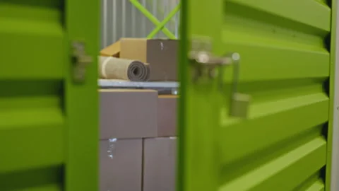 Open Padlock on Green Self Storage Unit Door Revealing Boxes Stock Footage 340286537
