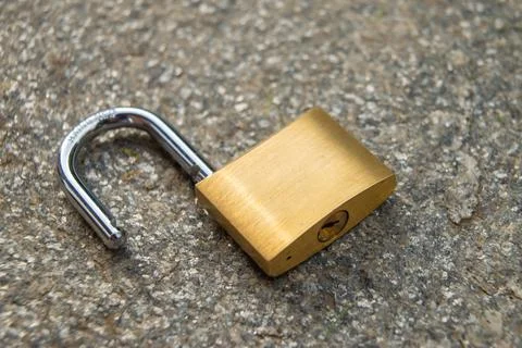 Open padlock, placed on the ground. Stock Photos