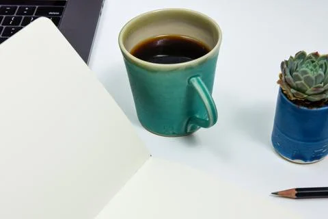 Open page in a blank paper note book on a work desk Stock Photos