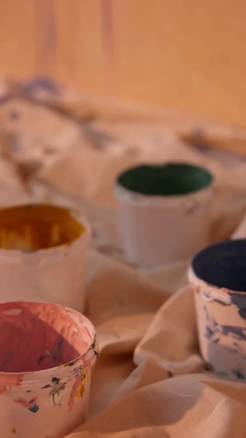 Open paint buckets sit on a cloth in studio Stock-Footage 331770167