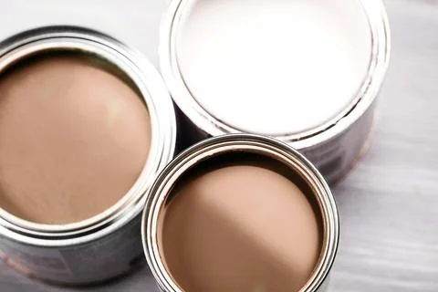 Open paint cans showcasing various shades of brown and white colors. Stock Photos