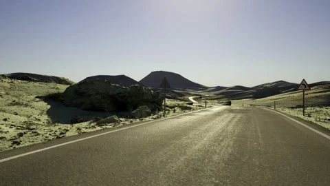 Open pavement traversing arid terrain towards distant elevated land Stock Footage 341826445