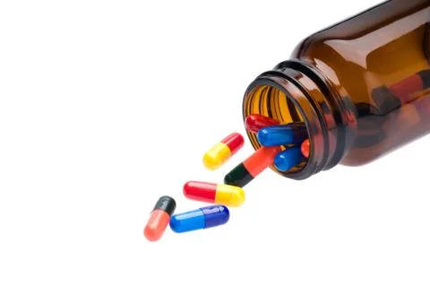 Open pharmaceutical bottle which spills colored capsules Foto stock