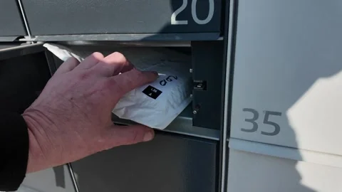 Open the pickup point box. Remove the package from the pick up point box. The Stock Footage 305472421