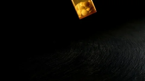 Open pill bottle falling on the black surface in slow motion Stock Footage 81230954