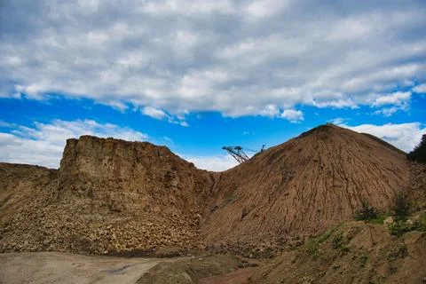 Open Pit Limestone Quarry Wall and Earth Mound with Mining Crane Stock Photos