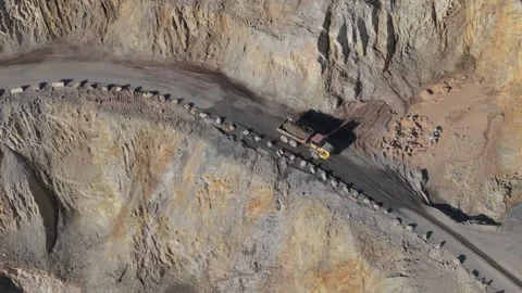 Open pit mine with heavy trucks hauling rock to nearby quarry processing plant Stock Footage 314719829