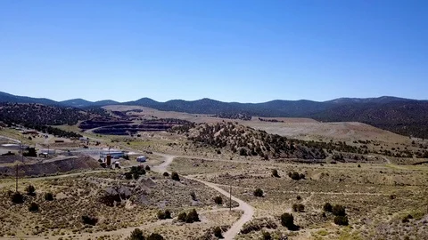 Open pit mine quarry flanked by disued mine and mining equipment Stock Footage 92825035