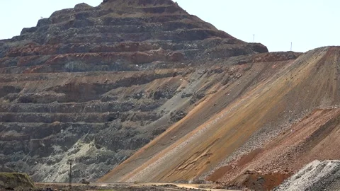 Open pit mine spreads across terraced benches with haul roads - Mining Terrain Stock Footage 339819117