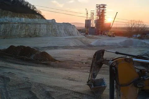 Open pit mining site of construction sand stone materials with excavator Stock Photos