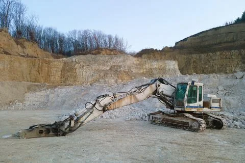 Open pit mining site of construction sand stone materials with excavator Stock Photos