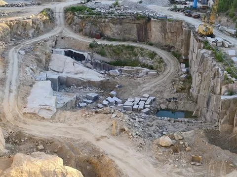 Open pit quarry scene with layered rock faces, dirt roads, scattered stone .. Stock Photos