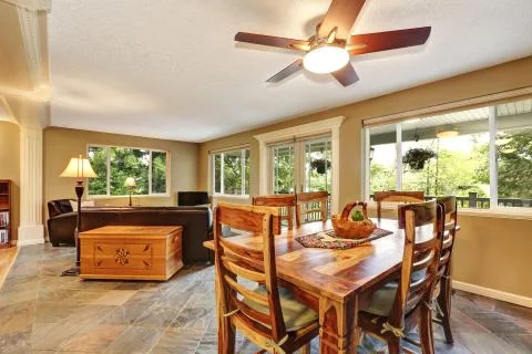 Open plan dining room with rustic wooden table and chair set. Connected to th Stock Photos