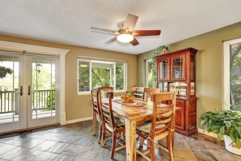 Open plan dining room with rustic wooden table and chair set,  natural stone  Stock Photos