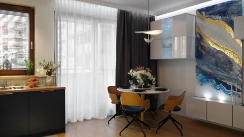 Open plan kitchen and dining room studio with motorized curtains opening Stock Footage 347875038
