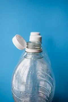 Open Plastic Bottle with Cap on Blue Background, Packaging and Recycling Detail Foto stock
