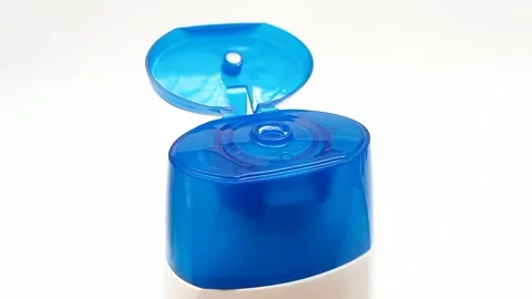 An open plastic bottle cap rotating on a white background, blue color open cap Video stock 306445708