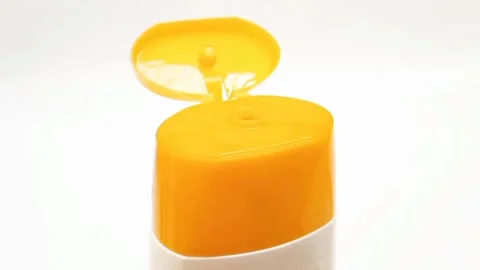 An open plastic bottle cap rotating on a white background, yellow color open cap Stock Footage 306515047