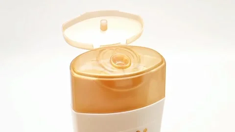 An open plastic bottle cap rotating on a white background, golden color open cap Stock Footage 306515052