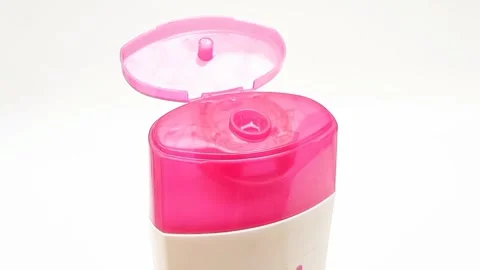 An open plastic bottle cap rotating on a white background, pink color open cap Stock Footage 306515195