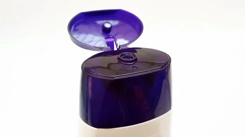 An open plastic bottle cap rotating on a white background, navy blue color cap Stock Footage 306515197