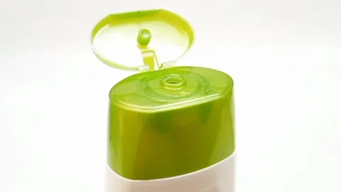 An open plastic bottle cap rotating on a white background, olive green open cap Video stock 306515249