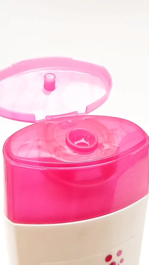 An open plastic bottle cap rotating on a white background, pink color open cap Stock Footage 306570591