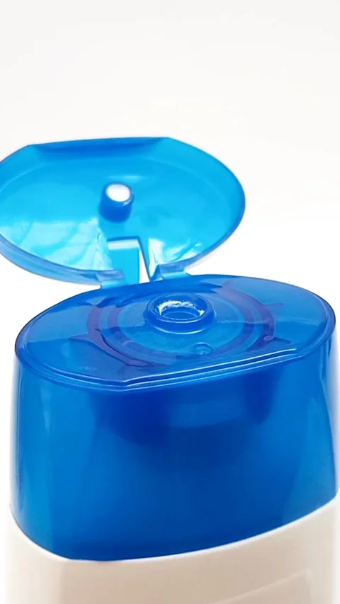An open plastic bottle cap rotating on a white background, blue color open cap Stock Footage 306570592