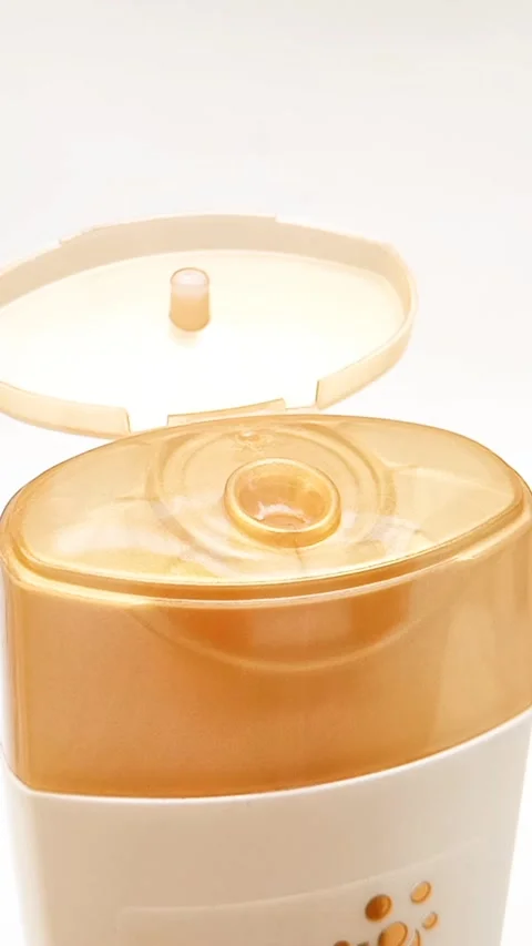 An open plastic bottle cap rotating on a white background, golden color open cap Stock Footage 306570666