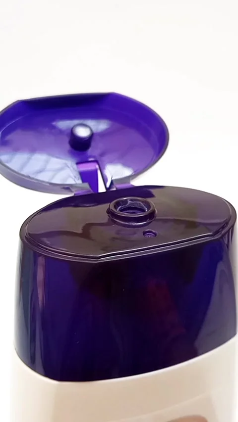 An open plastic bottle cap rotating on a white background, navy blue color cap Stock Footage 306570668