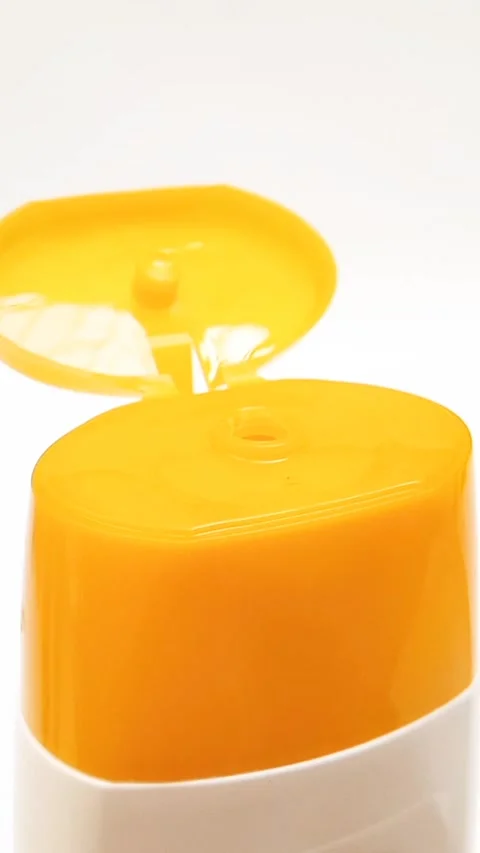 An open plastic bottle cap rotating on a white background, yellow color cap Video stock 306570694