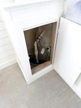 Open Plumbing Access Panel Inside Residential Bathroom Foto stock