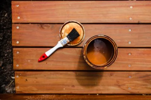 Open pot of decking stain on top of outdoor wooden stairs, home improvement a Stock Photos