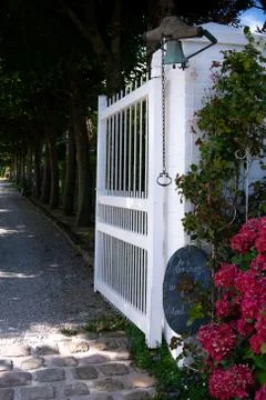 Open property gate on tree-lined driveway Stock Photos