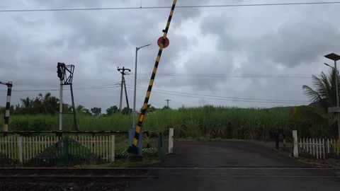 An open railroad crossing gate under a dramatic storm sky symbolizing clearance, Stock Footage 342477281