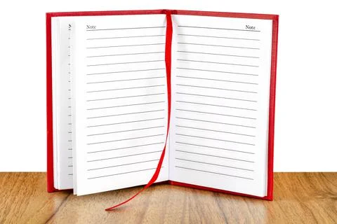 Open red lined notebook standing on a wooden table, isolated on a white backg Stock Photos