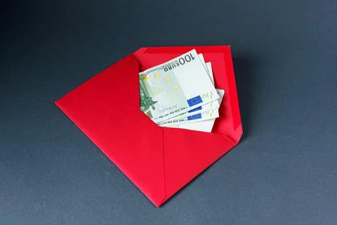 Open red paper envelope with one hundred euro banknotes on a gray background Stock Photos