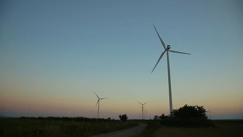 Open road int he field with wind mills on it. Sunrise moment. Eco friendly gr Stock Footage 93368412